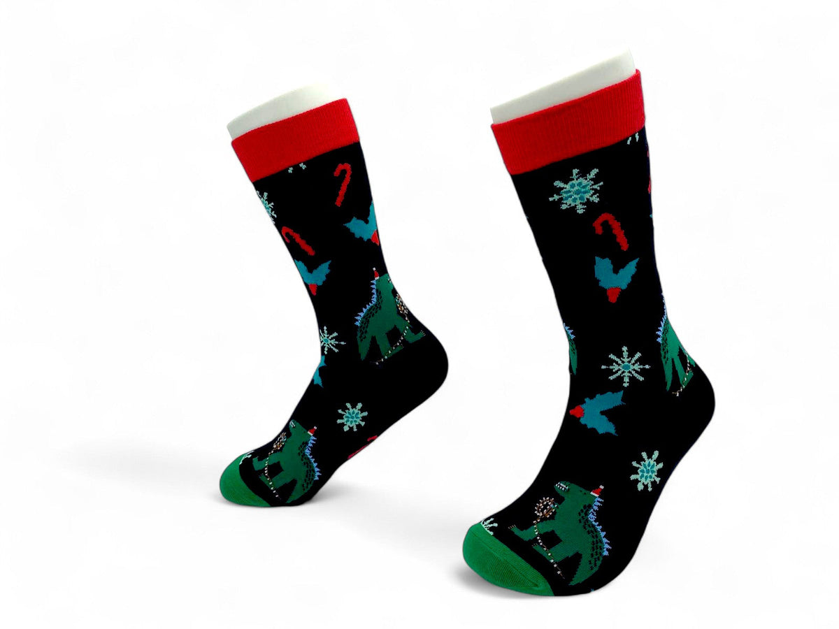 Side view of black Christmas crew socks with godzilla in Santa hats, candy canes and holly