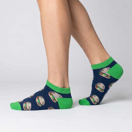 Side view of navy burger ankle socks worn mid-step, showing the green heel