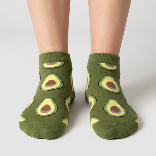 Olive green avocado ankle socks with halved avocado print, worn on foot, front three-quarter view