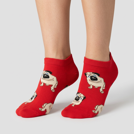 Bright red pug print ankle socks with cream googly-eyed pugs, worn on foot, front three-quarter view