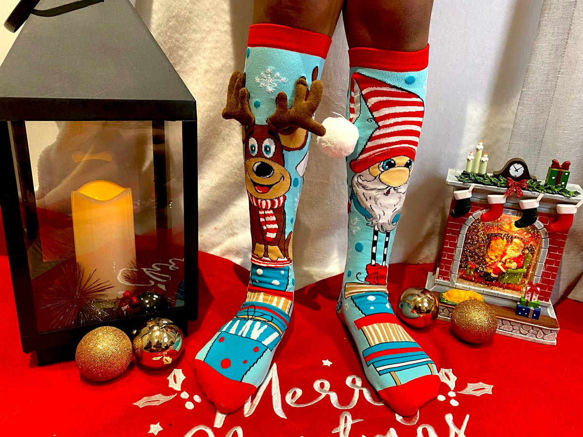 Santa and reindeer Christmas knee socks worn against a festive Merry Christmas background